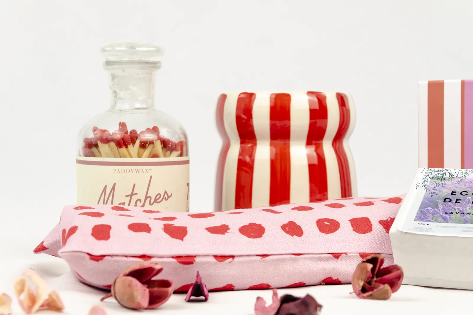 Caja de regalo «Aromas de La Provenza» con vela aromática Paddywax de rayas rojas y blancas, cerillas en botella de vidrio, jabón ecológico de lavanda y almohada rosa con corazones rojos.