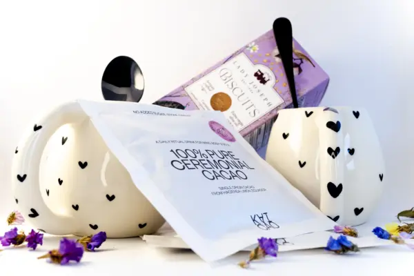 Caja regalo Musuka "Chocolate para dos" que contiene - dos tazas de cerámica, cucharillas de color negro, un paquete de galletas de caramelo crujiente Lady Joseph y dos sobres de “100% Pure Ceremonial Cacao” de Kaicao.