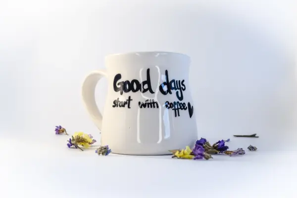 Caja regalo Musuka "Los buenos días empiezan con café" que contiene una cafetera Magefesa, una taza de cerámica artesanal en la que se lee "good days start with coffe", un paquete de galletas de cacao Lady Joseph, un paquete de Café Molido Bio “Tierra Madre Mujer”, de Oxfam Intermón Comercio Justo y un tarro de cacahuetes recubiertos de chocolate blanco y negro.