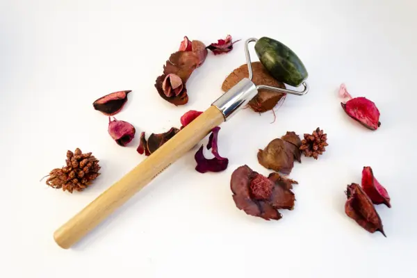 Caja de regalo Musuka "Mímate" que contiene: Una vela con olor a higuera silvestre y cedro, una herramienta para velas, un tarro de sales de baño con aroma a hibisco y rosa, un rodillo de masaje facial que se convierte en bolígrafo y una botella “Paddywax” con cerillas.
