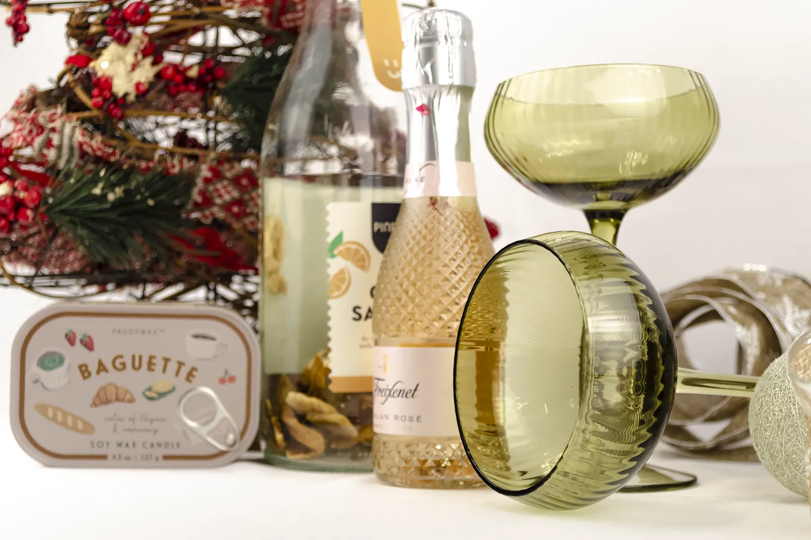 Caja Musuka “Regalo de Navidad 11" que contiene: Una botella de sangría de cava Pineut, con una mezcla de naranja y mango deshidratados. Una mini botella de vino Freixenet "Italian Rosé” de 20 cl. Una vela enlatada Paddywax “Baguette".