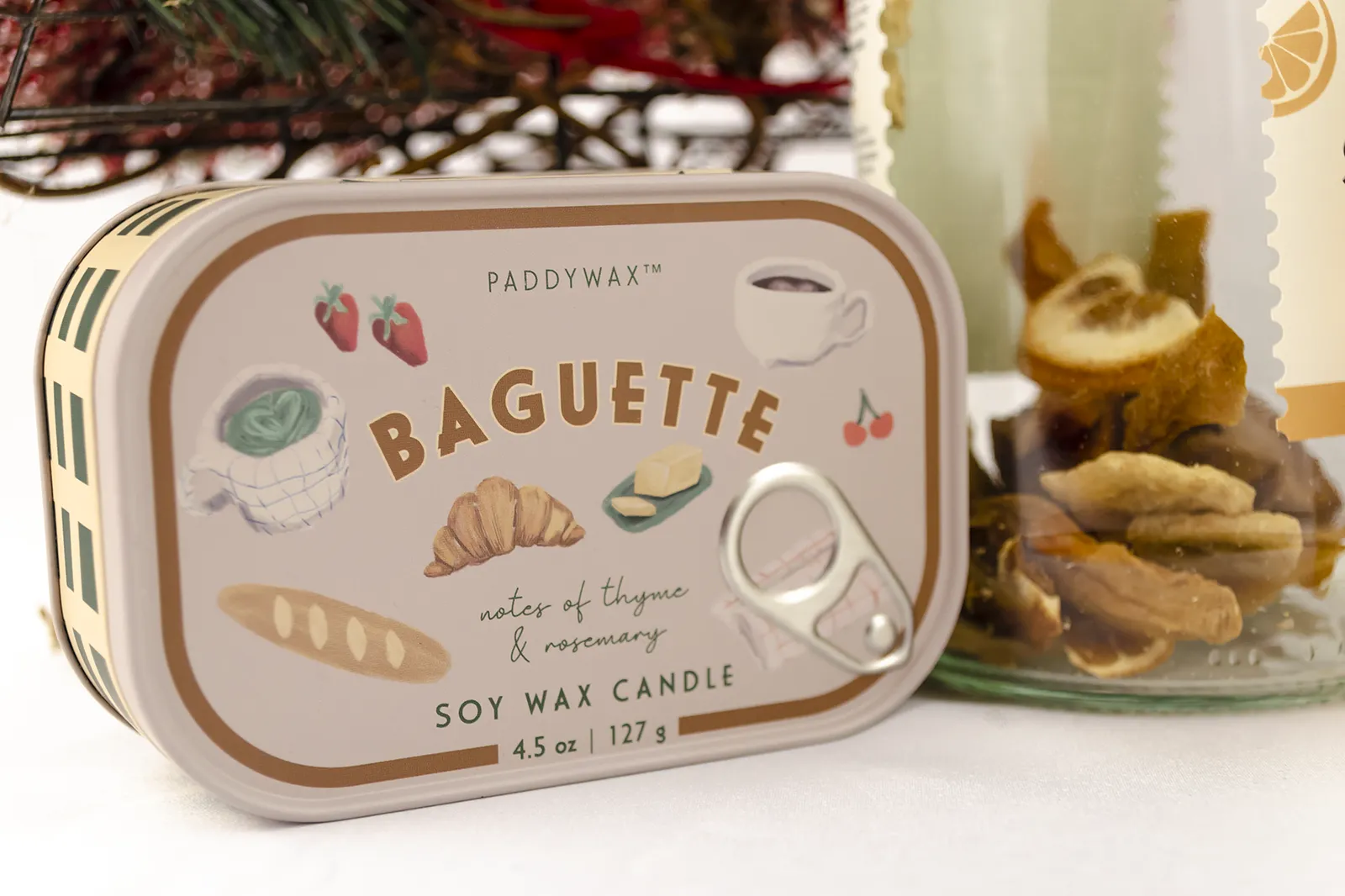 Caja Musuka “Regalo de Navidad 11" que contiene: Una botella de sangría de cava Pineut, con una mezcla de naranja y mango deshidratados. Una mini botella de vino Freixenet "Italian Rosé” de 20 cl. Una vela enlatada Paddywax “Baguette".