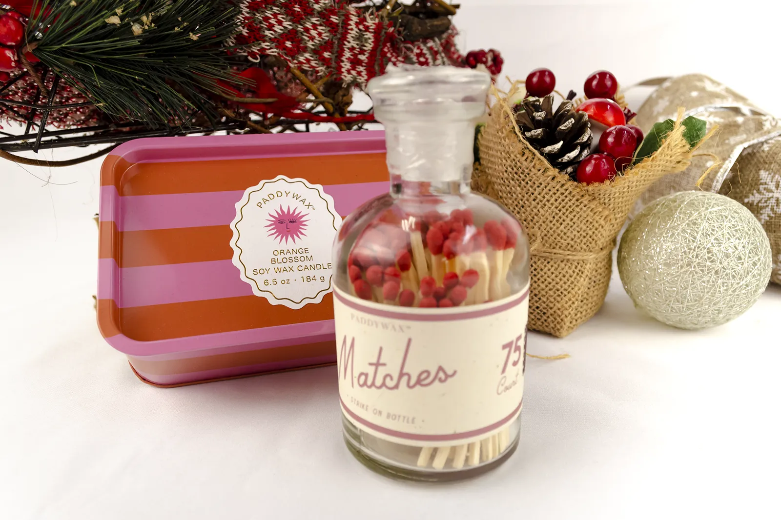 Caja Musuka “Regalo de Navidad 12" que contiene: Una vela en lata Paddywax “Orange Blossom”, y una botella con cerillas “Paddywax”.