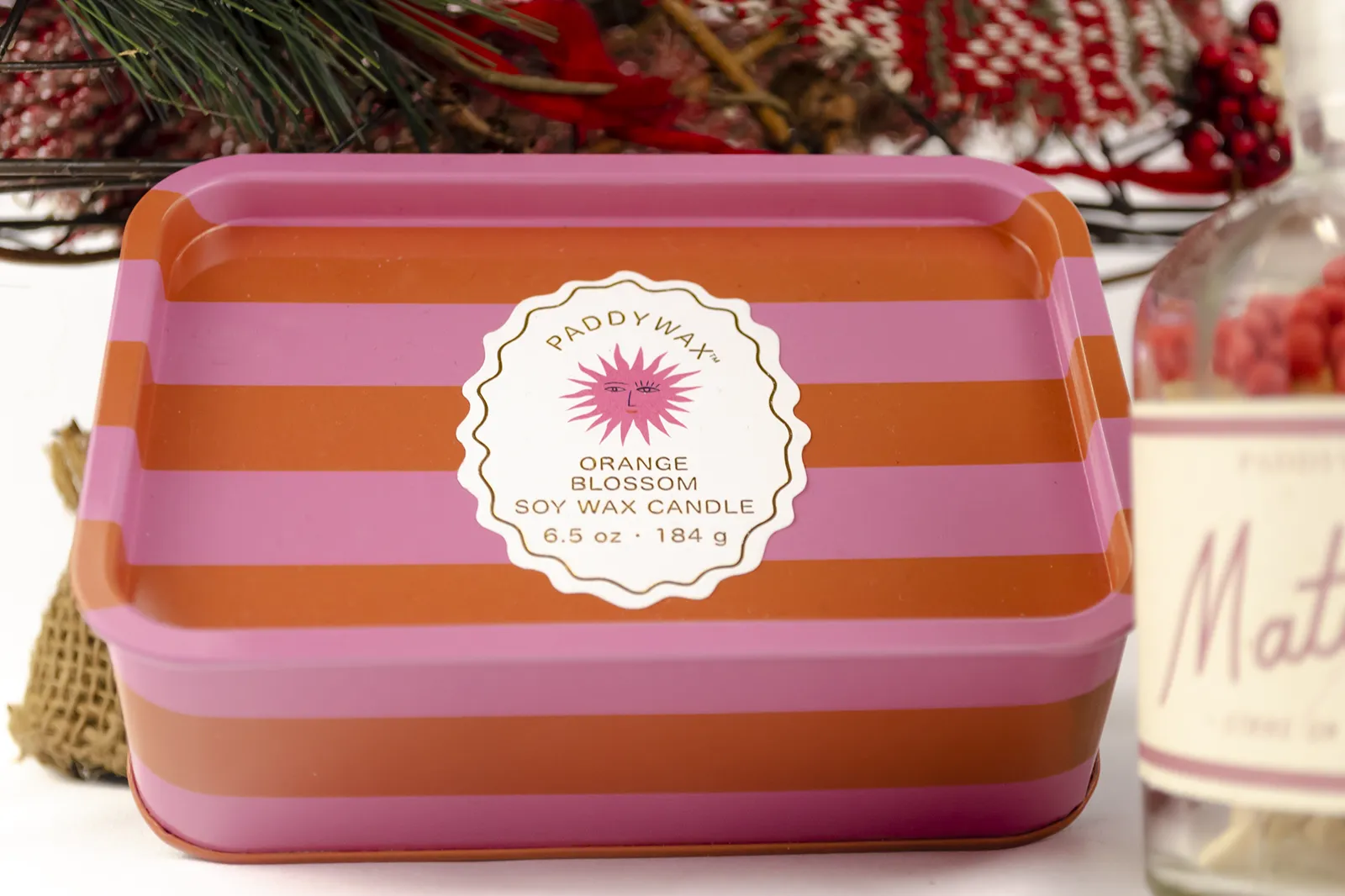 Caja Musuka “Regalo de Navidad 12" que contiene: Una vela en lata Paddywax “Orange Blossom”, y una botella con cerillas “Paddywax”.