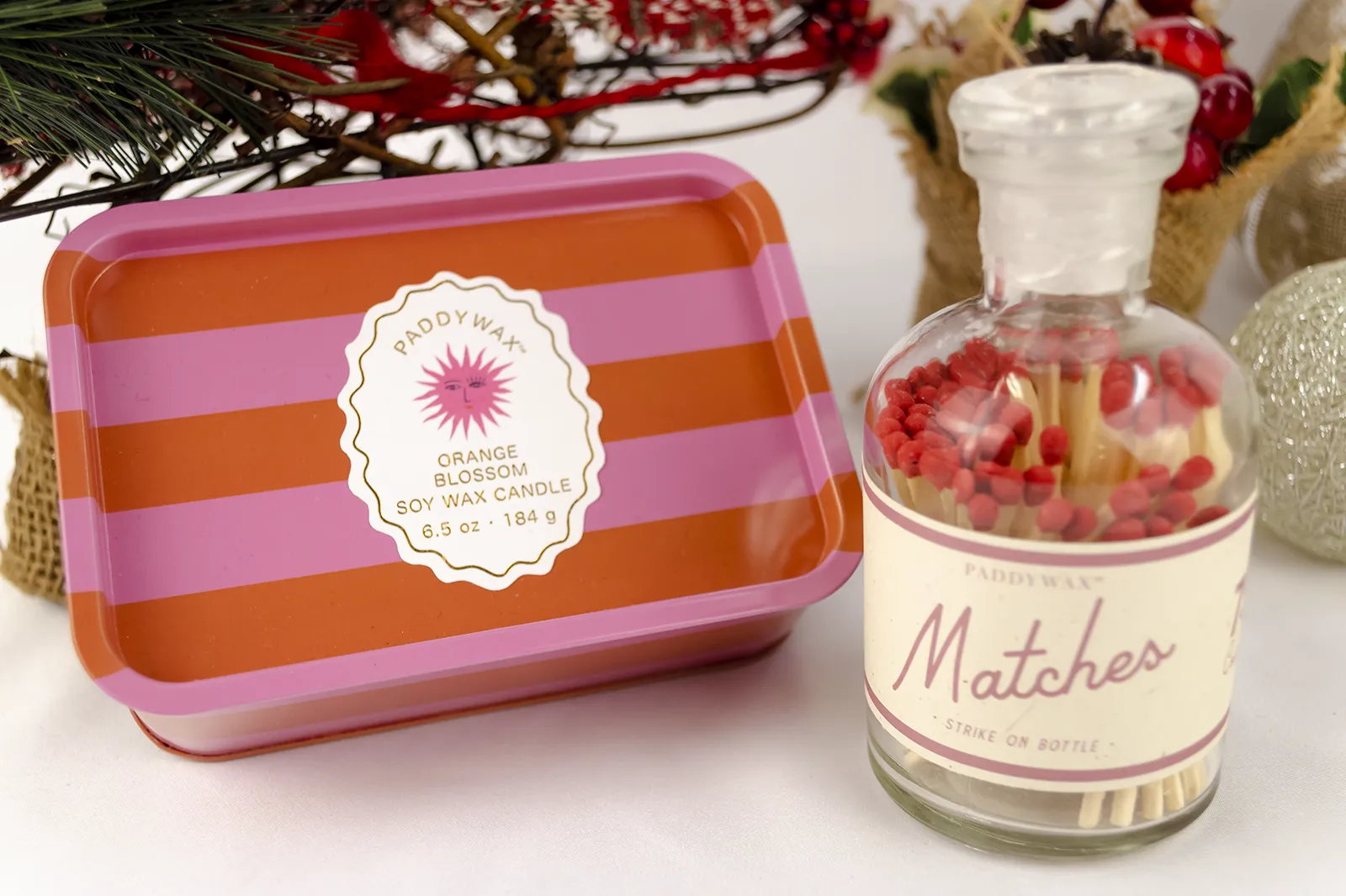 Caja Musuka “Regalo de Navidad 12" que contiene: Una vela en lata Paddywax “Orange Blossom”, y una botella con cerillas “Paddywax”.