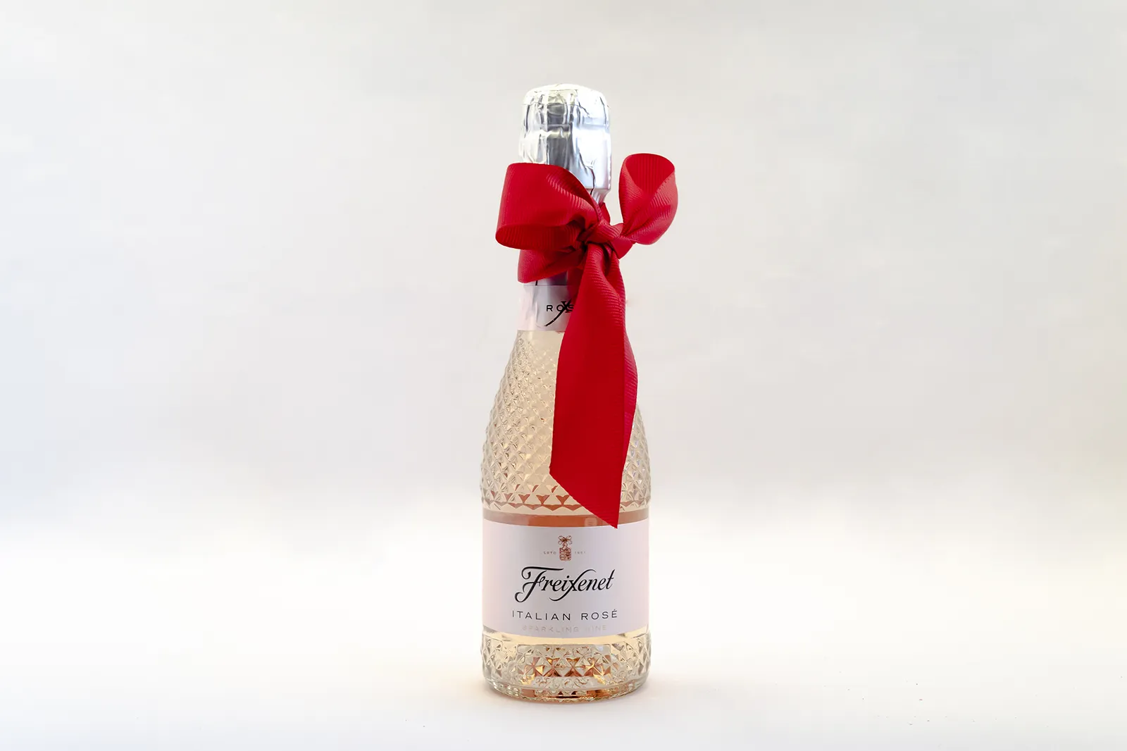 Caja Musuka “Regalo de Navidad 24" que contiene: Una mini botella de vino Freixenet "Italian Rosé”. Un par de copas estilo vintage Here’s How, hechas de un elegante vidrio de color rosa.