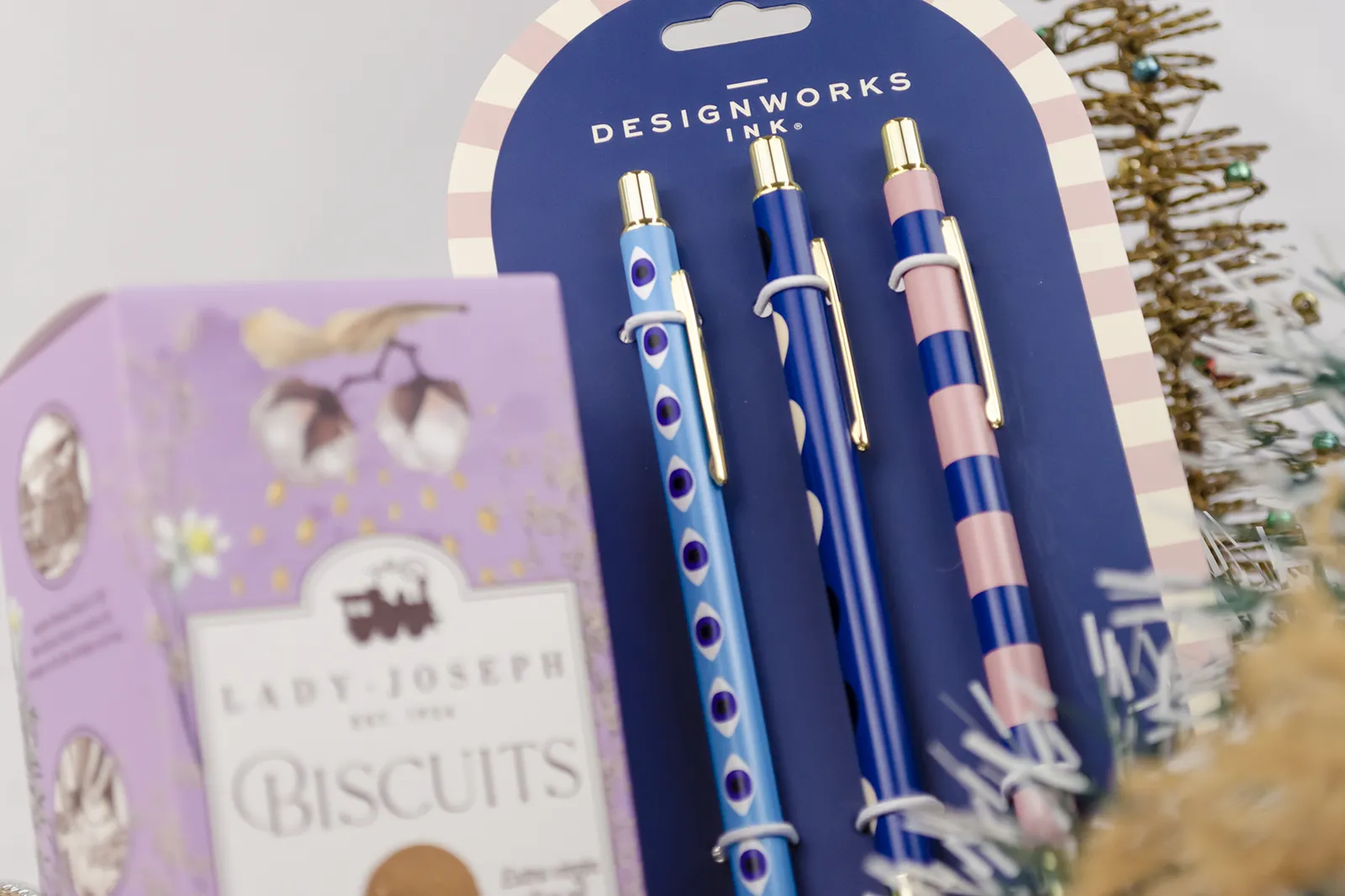 Caja Musuka “Regalo de Navidad 3" que contiene: galletas de caramelo Lady Joseph, tres bolígrafos Designworks Ink, con diferentes estampados y detalles en color dorado. Un pack de separadores de hojas Designworks Ink, de color dorado y con dibujo de una flor. Un tazón rosa de la marca Bidasoa.
