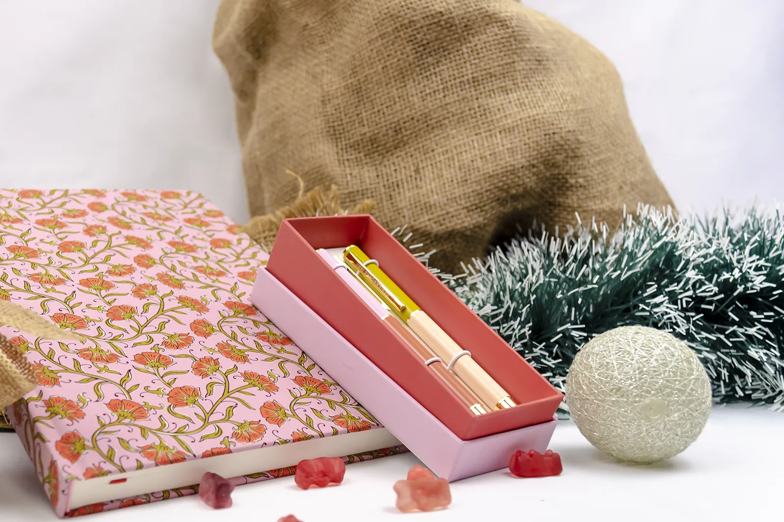 Caja Musuka “Regalo de Navidad 9" que contiene: Una agenda Designworks Ink de gran tamaño, con estampado vintage de flores. Un set de dos bolígrafos Designworks Ink de tinta negra, en diferentes colores.