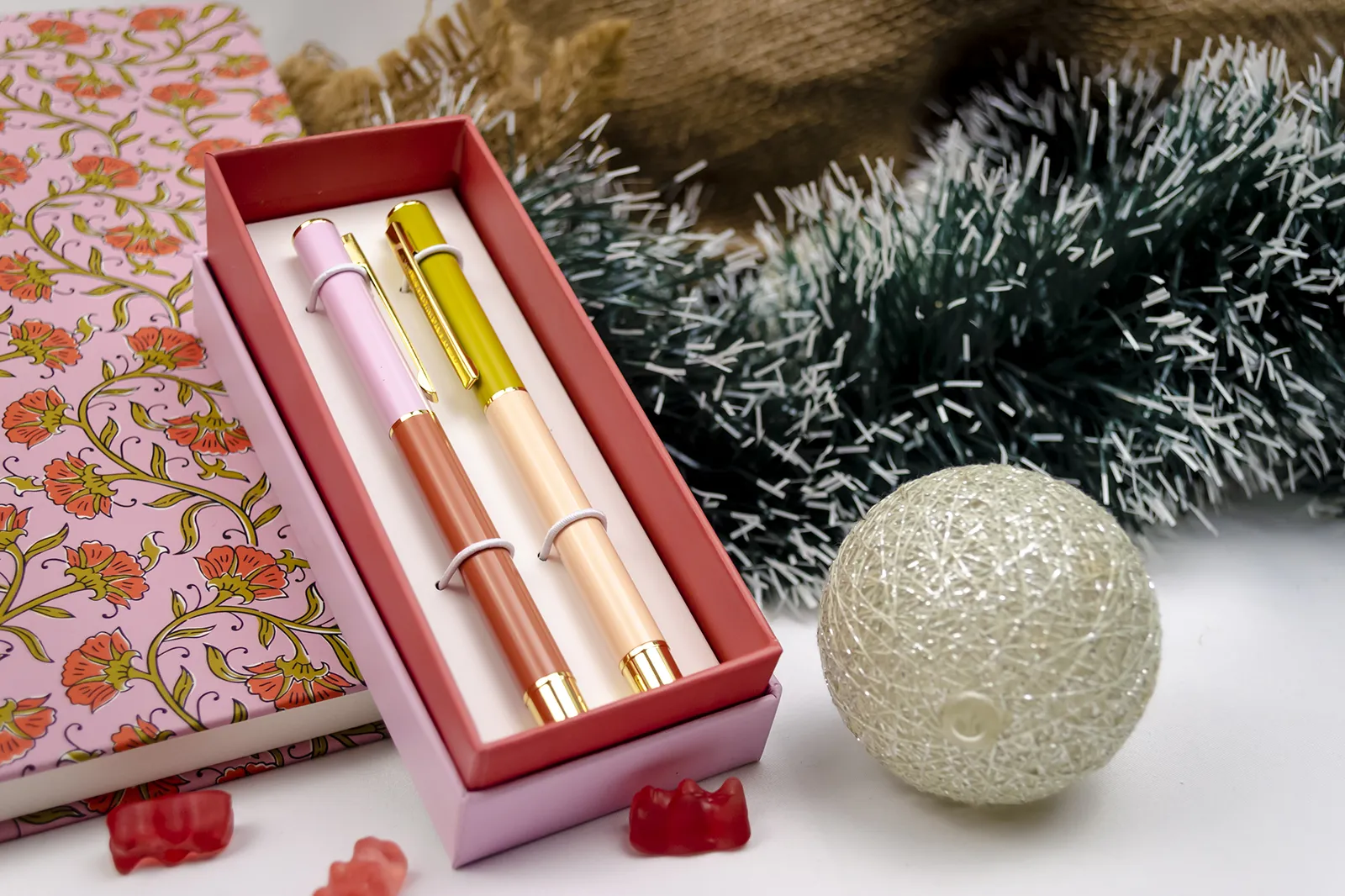 Caja Musuka “Regalo de Navidad 9" que contiene: Una agenda Designworks Ink de gran tamaño, con estampado vintage de flores. Un set de dos bolígrafos Designworks Ink de tinta negra, en diferentes colores.