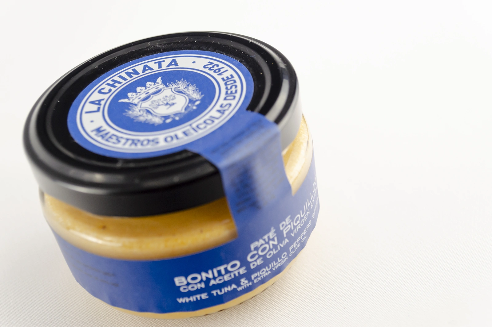 Bote de paté gourmet presentado como parte de una selección de aperitivos para un pícnic, ideal para acompañar una escapada gastronómica al aire libre.