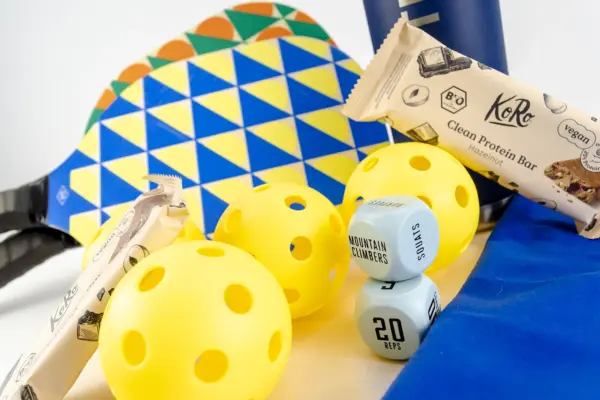 Caja regalo Musuka "Ready to Play" que contiene: botella para agua, juego de dados para ejercicios de fitness, juego de palas pickleball, barritas veganas de proteinas Koro, toalla de microfibra