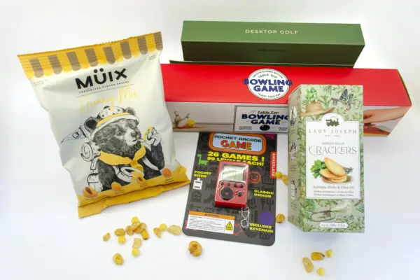 Caja regalo Musuka "Tarde de juegos" que contiene: mini juego de bolos, arcade de bolsillo con 26 juegos, crackers veganos Lady Joseph, paquete de frutos secos Müix Snacks, mini juego de golf de mesa.