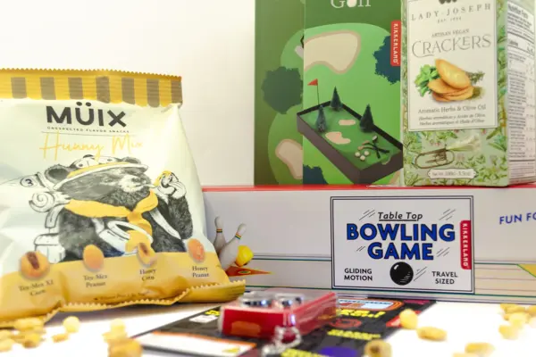 Caja regalo Musuka "Tarde de juegos" que contiene: mini juego de bolos, arcade de bolsillo con 26 juegos, crackers veganos Lady Joseph, paquete de frutos secos Müix Snacks, mini juego de golf de mesa.