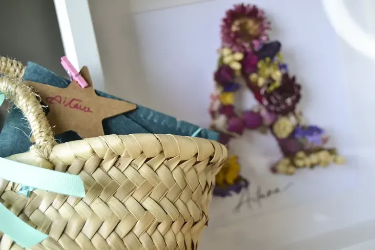 Cuadro de flores preservadas personalizado con la inicial A y el nombre Aitana, en marco blanco