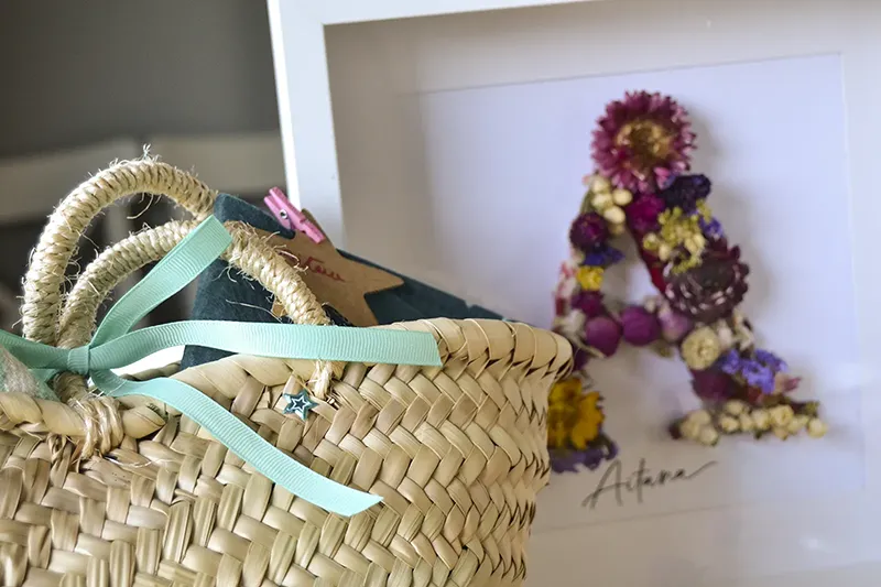 Regalo a medida con cuadro de flores preservadas personalizado y cesta de esparto con un regalo envuelto