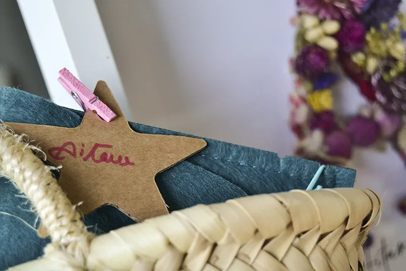 Cuadro de flores preservadas personalizado con nombre Aitana junto a cesta de esparto y regalo decorado con estrella personalizada