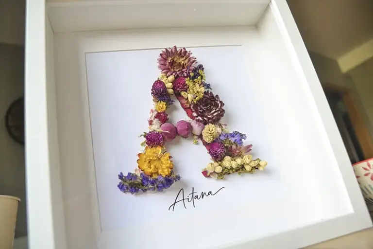 Detalle de cuadro de flores preservadas personalizado con la inicial A formada con flores naturales