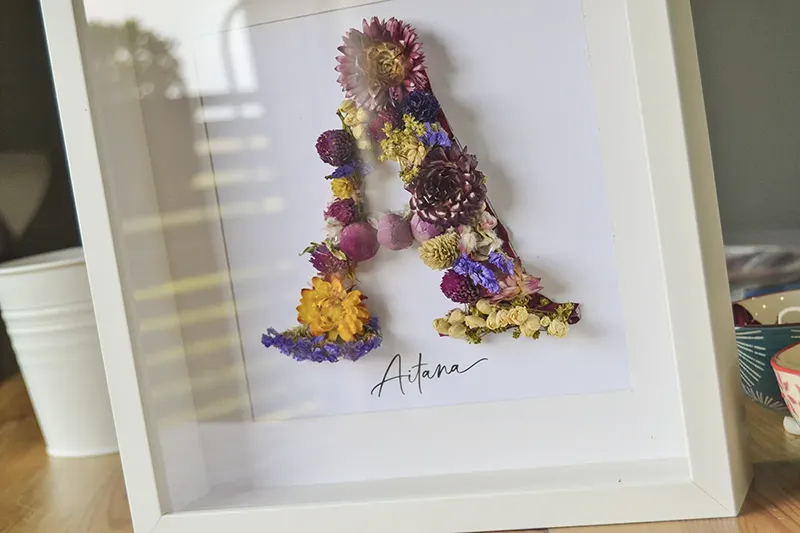 Cuadro personalizado de flores preservadas con nombre Aitana y marco blanco
