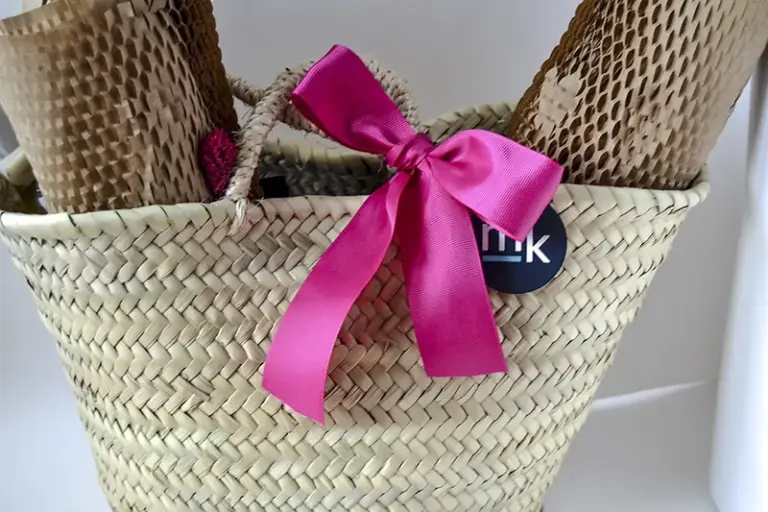 Regalo a medida para novios con cesta de esparto, productos gourmet, copas personalizadas y lazo rosa