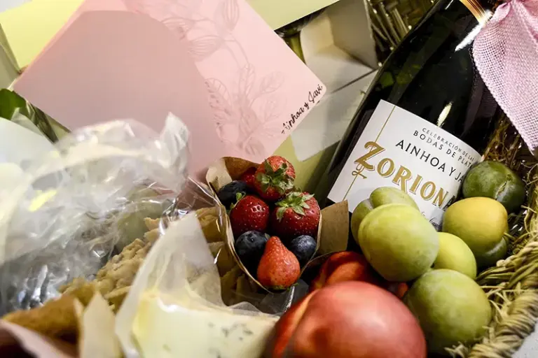 Regalo personalizado para bodas de plata con cava, frutas, chocolate, planta y copas en cesta de esparto