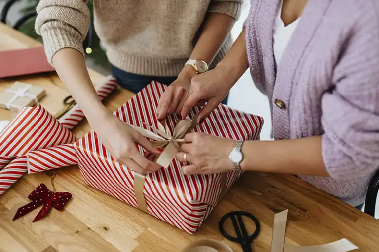 Dos mujeres envonviendo regalos a la carta personalizados